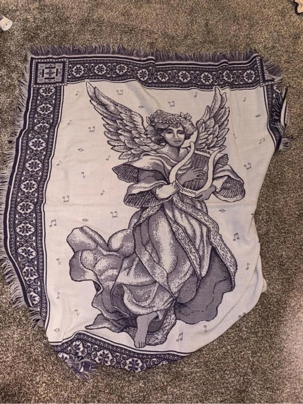 Purple and white tapestry blanket with music notes and angel playing harp